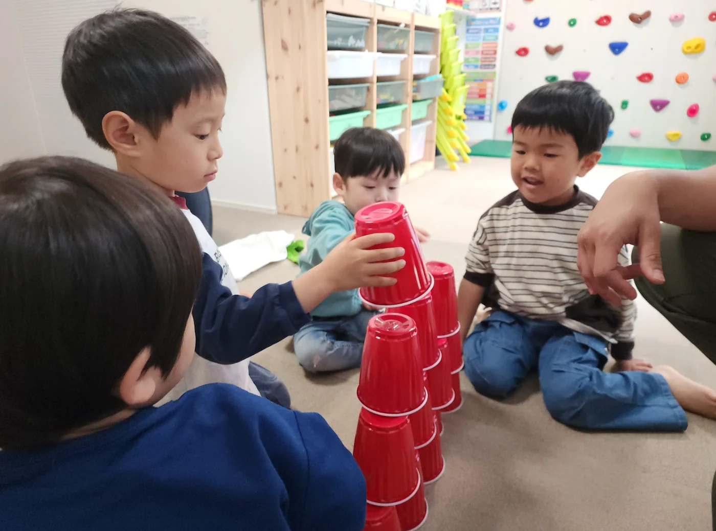 子どもたちがカップを使った英語ゲームで順番を待ちながら活動している様子