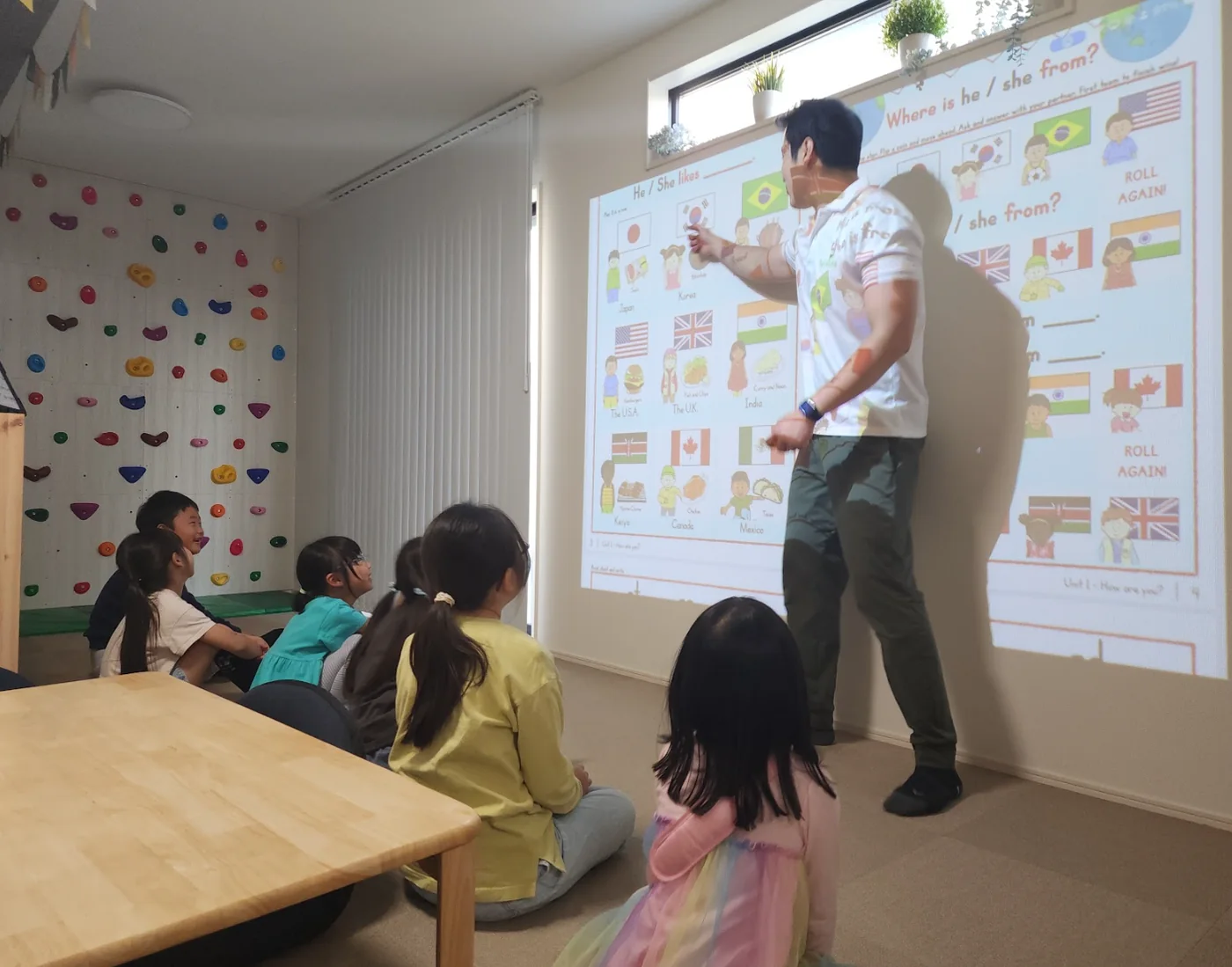 小学生の子どもたちがプロジェクターを使った英語レッスンに参加している様子