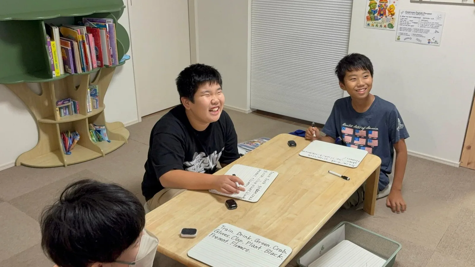 ミニホワイトボードを使いながら英語で答えるSproutsの小学生