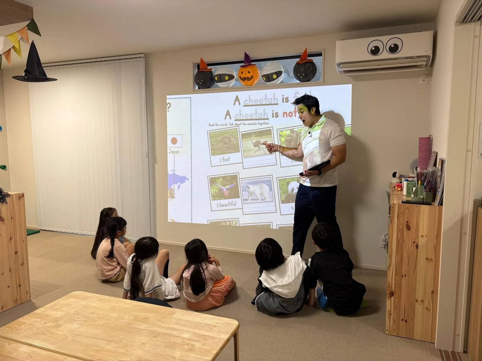 英語教材を投影しながら子どもたちに問いかけるSproutsのレッスン