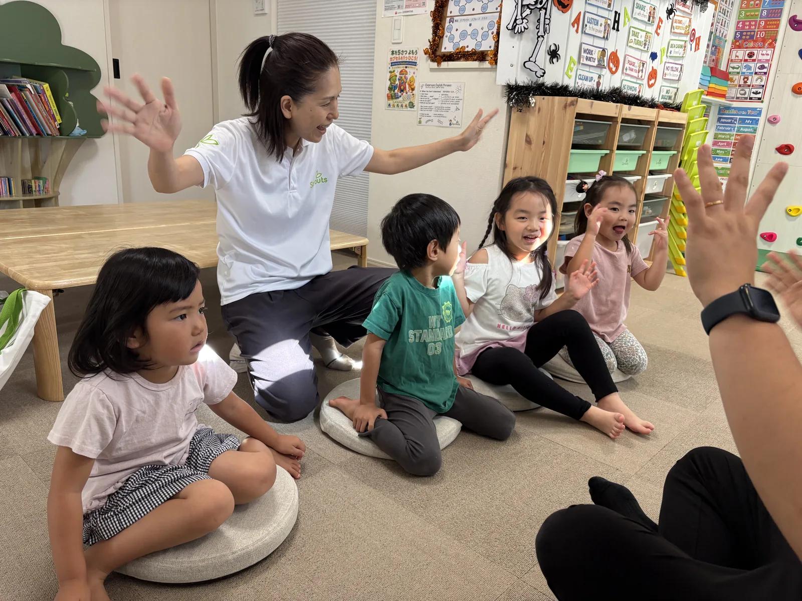 英語活動で先生と笑顔でやり取りするSproutsの子どもたち