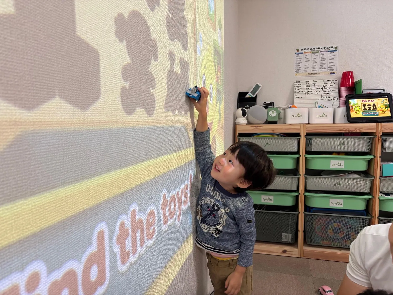 小さな子どもがプロジェクターを使った英語活動に参加している様子