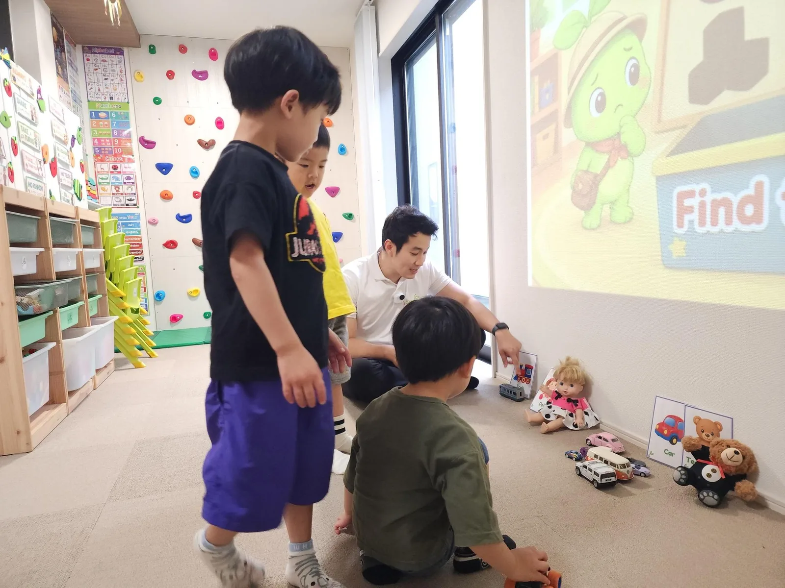子どもたちが先生と一緒におもちゃを使った英語活動をしている様子