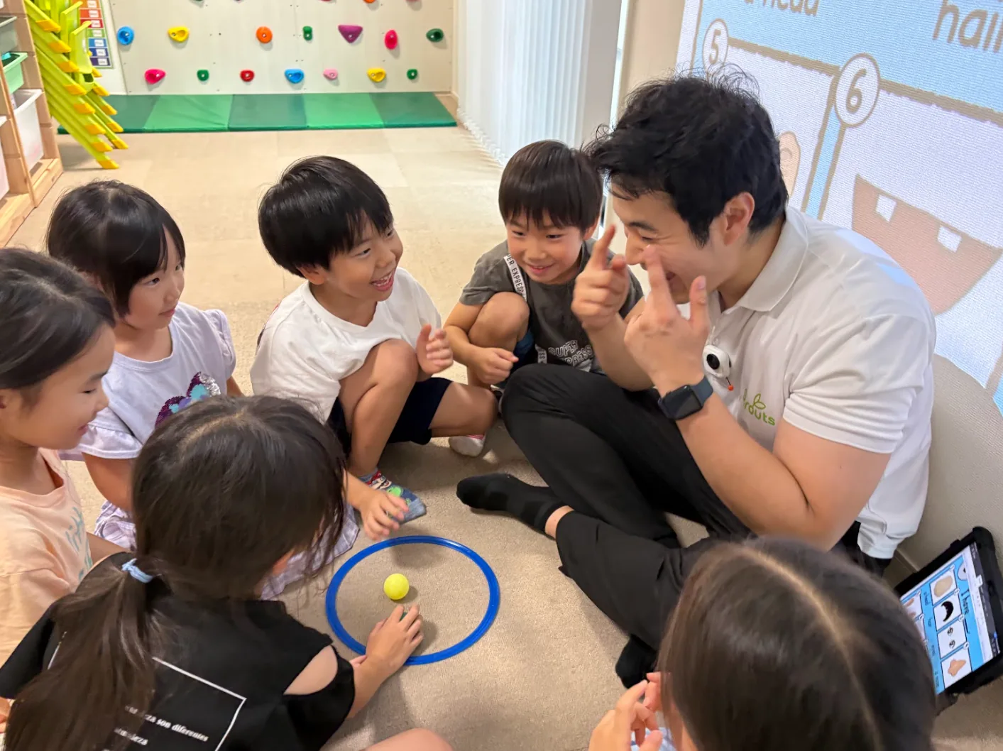 英語のゲーム活動で先生と楽しそうにやり取りするSproutsの子どもたち